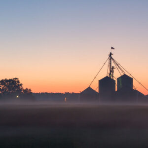 Sunrise behind a farm