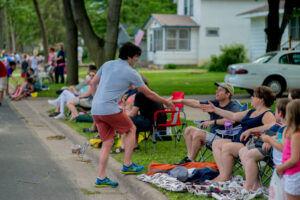 Matt shaking hands with people along parade route